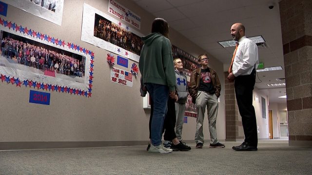 middle school students talking with teacher